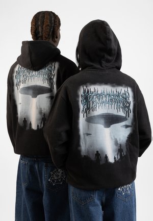 Black hoodie featuring a graphic design with alien figures and a spaceship, with a gradient blue and gray color scheme, worn by two people.