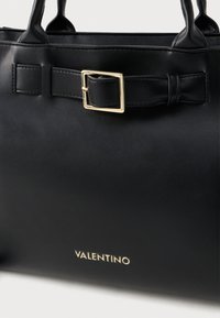 Black leather handbag with a rectangular shape, gold rectangular buckle detail, smooth texture, and 'Valentino' logo in gold lettering.