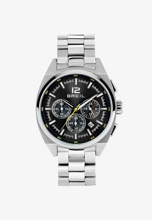 Sølv rustfrit stål ur med sort urskive, gule accenter, tre undermeter og et datovindue. Har et ledarmbånd og markante indikationer.