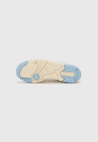 Fehér sneaker talp, textúrált gumipatternnel. Kék akcentus a lábujjaknál és a saroknál. Tapadásra és támogatásra tervezték.