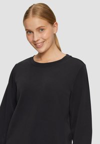 Zwarte sweatshirt met een ronde halslijn en lange mouwen, met een soepele textuur en een relaxed fit. Minimalistisch ontwerp, zonder zichtbare patronen.