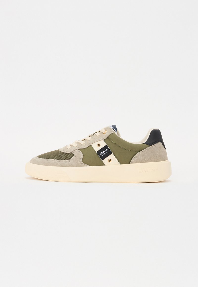 Grønne og beige sneakers med en kombinasjon av semsket skinn og tekstilmaterialer, en kremfarget såle, snøring foran og detaljer med logo på siden.