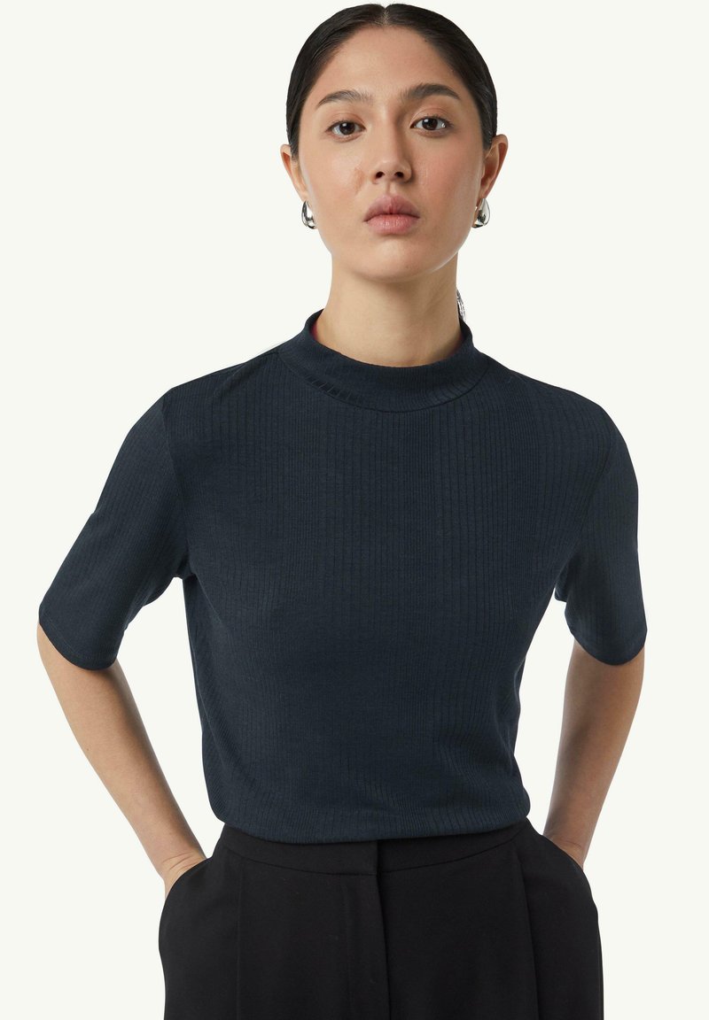 Ciemnoniebieski, prążkowany top z krótkim rękawem o wysokim dekolcie. Wykonany z lekkiego materiału, charakteryzuje się subtelną teksturą i dopasowanym krojem.