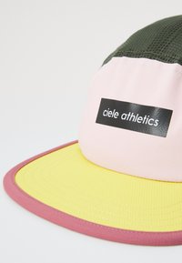 Mehrfarbige Kappe mit einem pinken Oberteil, gelbem Schirm und grünem Netzrücken. Verfügt über ein schwarzes Logo-Patch mit der Aufschrift "ciele athletics". Strukturierter Stoff.