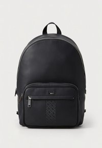 Musta reppu, jossa on sileä nahkapinta, pyöreä muoto, etutasku vetoketjulla ja punotulla kuviolla sekä kantokahva päällä.