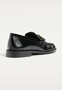 Černé kožené mokasíny s lesklým povrchem, nízkým blokovým podpatkem a nabíraným detailem na přední části, s akcentem zlatého tónu ve tvaru spony.