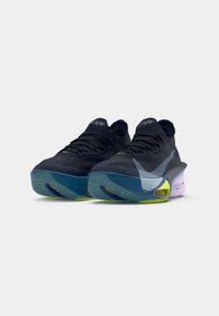 Ciemnoniebieskie buty sportowe z teksturowanym cholewką z dzianiny, z jasnoniebieskim logo w kształcie łuku, wielokolorową podeszwą z zielonymi i fioletowymi akcentami.