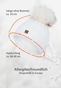 White knitted beanie with a fur pom-pom, approximately 22 cm tall. Features a snug fit, with a circumference of 48-58 cm. Allergy-friendly.