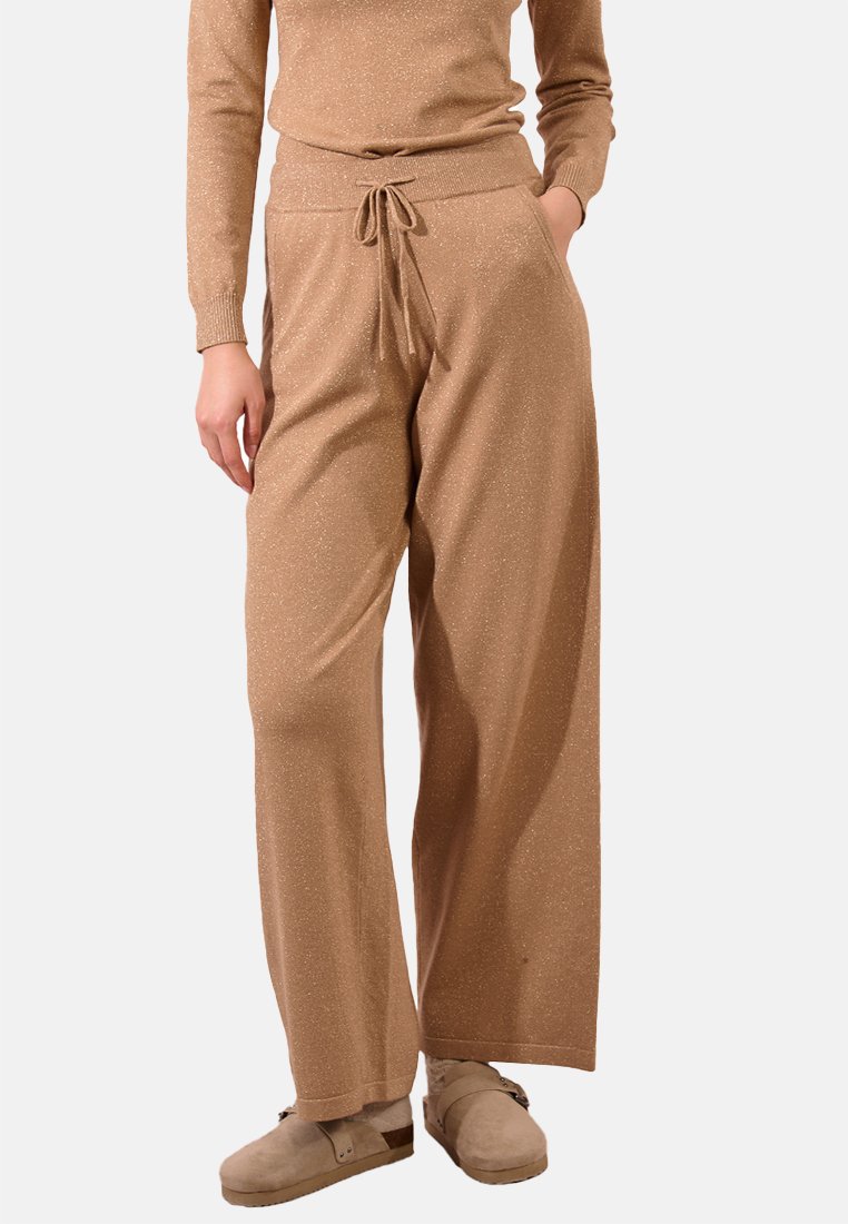 Pantaloni a gamba larga beige e scintillanti con elasticità in vita e cordoncino. Presentano tasche laterali e una texture morbida per il massimo comfort.