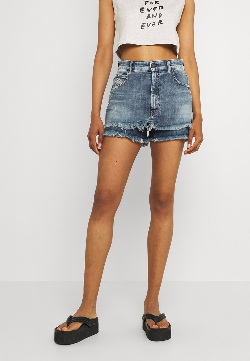 Světle modrá džínová minisukně s třepeným lemem, pětiprůstkovým designem a zapínáním na knoflíky vpředu. Kombinováno s černými platformovými žabkami.