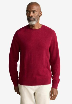Roter gestrickter Pullover mit Rundhalsausschnitt, langen Ärmeln und strukturiertem Stoff. Verfügt über gerippte Bündchen und Saum, hat ein weiches und warmes Aussehen.