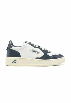 Sneaker basse in pelle bianca e blu navy con punta traforata, lacci, toppa con logo sul lato e suola spessa color avorio.