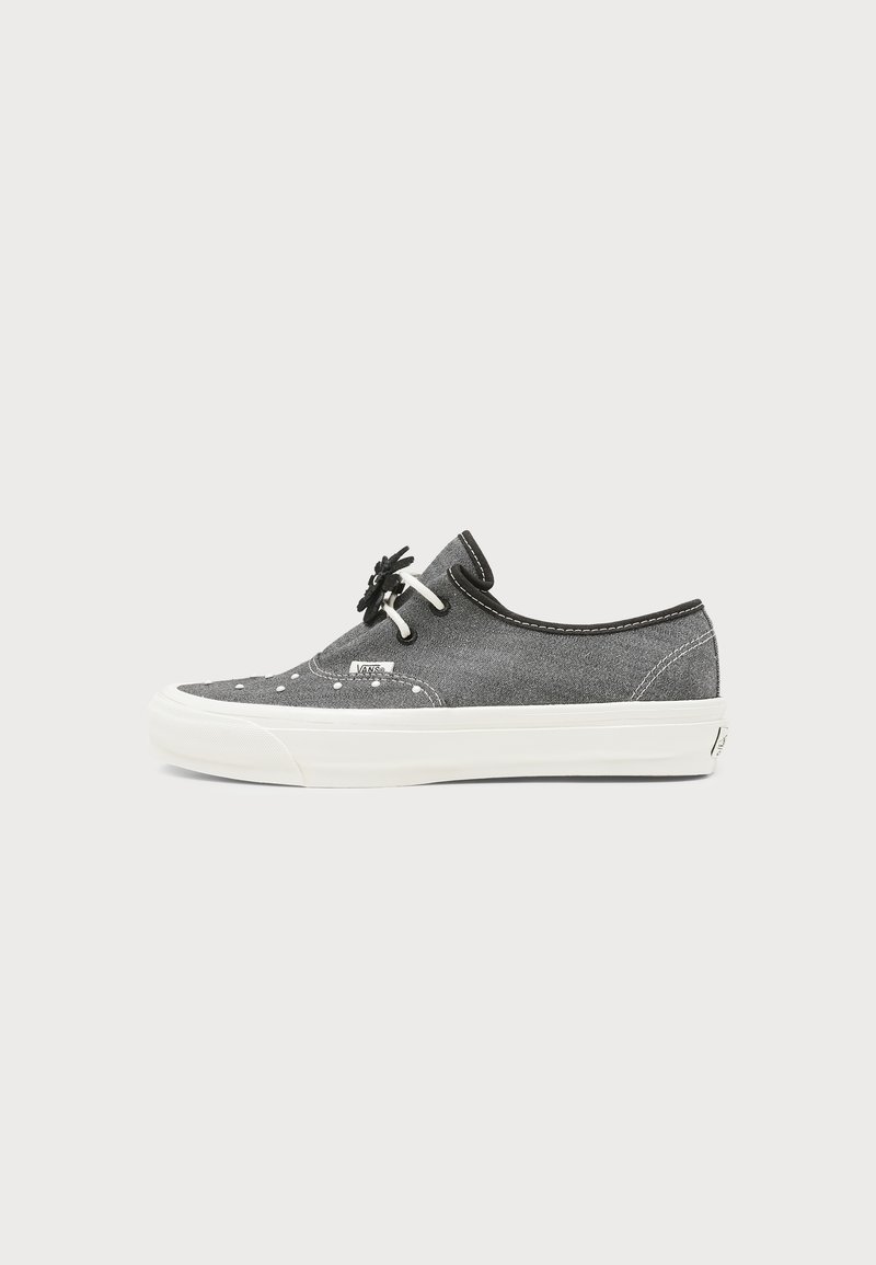 Γκρι χαμηλό παπούτσι Vans με λευκή σόλα, λευκή ραφή, ασπρόμαυρα κορδόνια και μικρή ετικέτα λογότυπου στο πλάι.