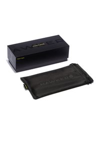 Črni pravokotni škatla z vtisnjenim napisom "HAWKERS", s mat teksturo. Ob njem leži ujemajoča se črna mikrovlakenska torbica z vrvico za zapiranje.