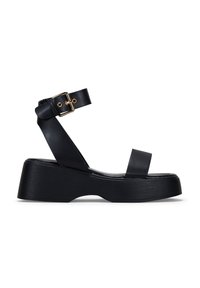 Sandalias de plataforma negras con un upper de cuero suave, que presentan una sola tira en el dedo del pie, una tira en el tobillo con una hebilla dorada y una suela de cuña texturizada.