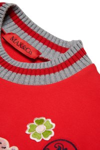 Felpa rossa con colletto a coste grigio a righe. Include motivi floreali ricamati in verde, rosa e blu. Etichetta del marchio visibile.