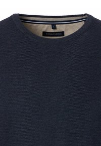 Marinblå texturerad rundhalsad tröja med beige inre krage och svart CASAMODA-märkesetikett i storlek large.