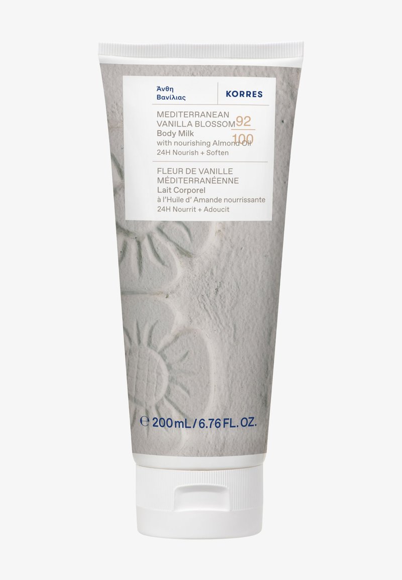 Tube de lait corporel Fleur de Vanille Méditerranéenne avec huile d'amande, nourrit et adoucit pendant 24 heures, 200 ml, design floral beige texturé.