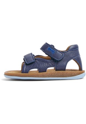 Marinblå läder sandal med två kardborreband, utskärningar, brun texturerad innersula och en ljusblå gummiyttersula.