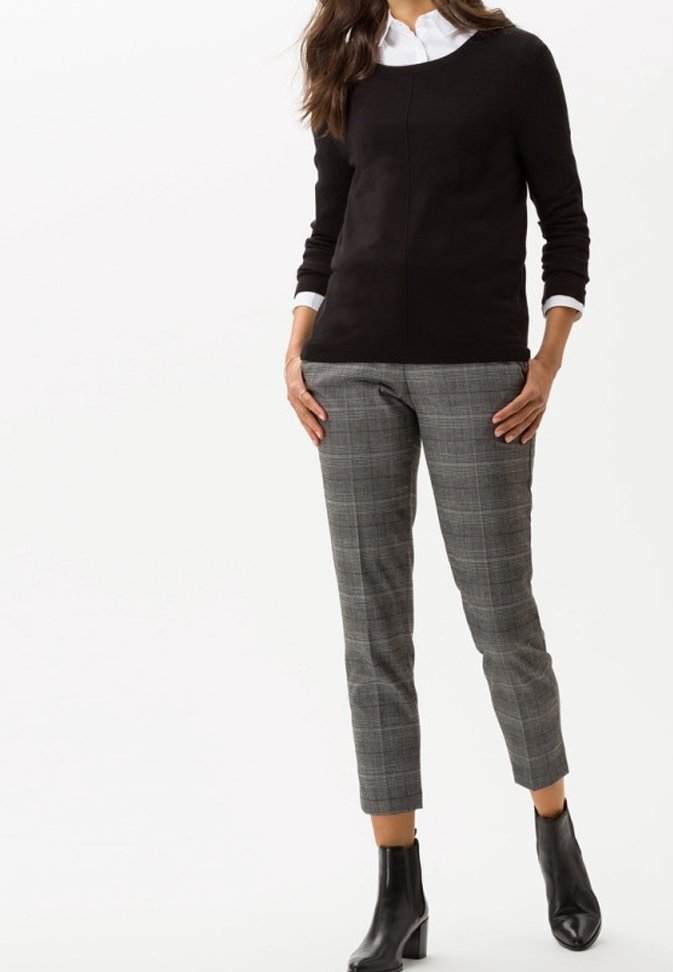 Černý pletený svetr s kulatým výstřihem v kombinaci se šedými kostkovanými zkrácenými kalhotami a černými kotníkovými botami. Hladká textura, přiléhavý střih.