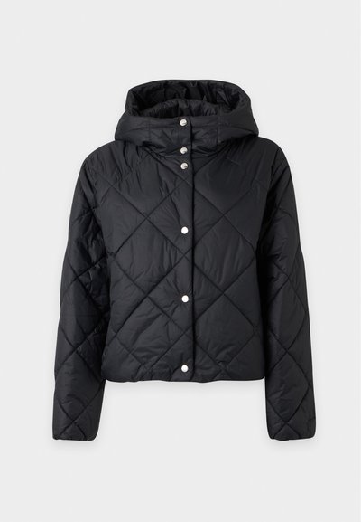 Veste matelassée noire avec coutures en losange, fermeture pression devant, manches longues et capuche rembourrée sur un fond uni clair.