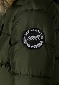 Olivgrüne Daunenjacke mit gestepptem Muster und einem runden Patch mit der Aufschrift "NEW GENERATION" in Weiß und Schwarz, mit Lorbeerakzenten.