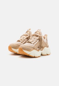 Chunky sneakers in beige and cream with textured fabric and smooth accents. Features thick rubber sole and decorative laces.