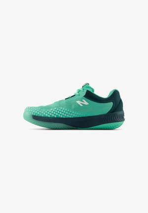 Lichtgroene en donker teal New Balance hardloopschoen met een gestructureerde grip en vetersluiting, zijaanzicht tegen een witte achtergrond.