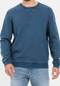 Felpa di cotone blu scuro con maniche lunghe, scollatura a girocollo, dettagli cuciti visibili e una piccola etichetta in pelle sul maniche sinistro.