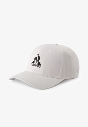 Gorra de béisbol blanca hecha de tela, con un logotipo bordado en negro de un gallo y el texto "Le Coq Sportif" en la parte frontal. Visera redondeada.