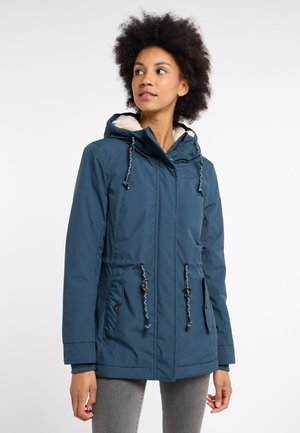 Blauwe waterdichte jas met een bontgevoerde capuchon, trekkoord in de taille, ritssluiting en zijzakken. Gestructureerde stof met contrasterende hardware.