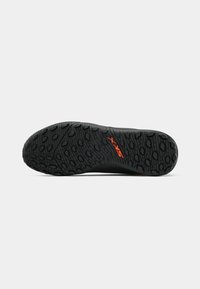 Black shoe sole with textured tread pattern and red "SXT" logo in the middle, shown against a plain white background.
