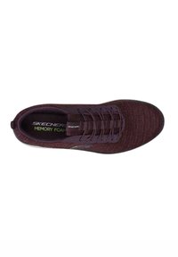 Zapato Skechers en púrpura oscuro con parte superior de punto texturizado, diseño de cordones y plantilla de espuma con memoria. Presenta el logo en el lateral y un acolchado adicional.