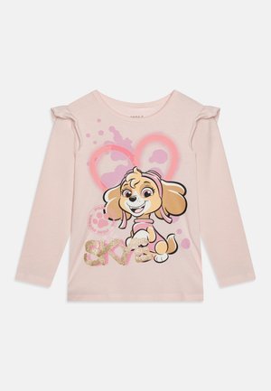Helles rosa Langarmshirt mit einem verspielten Cartoon-Hund, verziert mit glitzerndem "SKYE" und farbenfrohen Spritzern im Hintergrund.