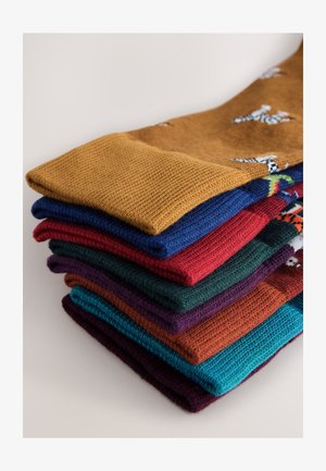 Katoenen sokken in diverse kleuren, waaronder mosterd, blauw, rood, groen, paars en petrol. Gestructureerd breisel met speelse patronen.