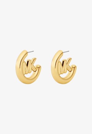 Goldfarbene Creolen zeichnen sich durch eine glatte, glänzende Oberfläche und ein eingebettetes "MK"-Logo aus. Das Design ist abgerundet und hat ein poliertes Finish.