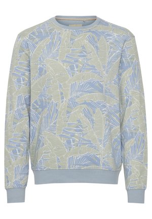 Gaiši zils sporta krekls ar zaļu un baltu tropisko lapu rakstu. Aprīkots ar ribotām aprocēm un apakšmalu, izgatavots no mīksta kokvilnas maisījuma auduma.