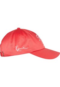 Piros baseball sapka fényes anyagból, fehér hímzett szöveggel és aláírással. Hátsó állítható pánt a megfelelő illeszkedés érdekében.