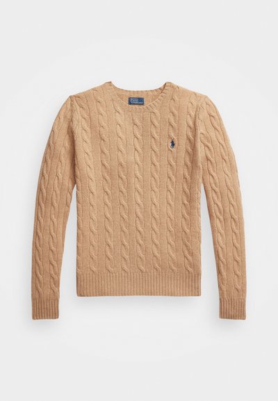 Pull en maille torsadée beige avec un col rond, des poignets et un ourlet côtelés, et un petit logo sur la poitrine gauche. Tissu doux et texturé.