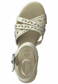 Beige Sandale mit dekorativen Ausschnitten, verstellbarem Riemen und gepolsterter Innensohle. Glatte Textur, runde Spitze, Gummisohle und Logodetail.