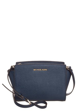 Marineblå Michael Kors crossbody taske med guldlogo, tekstureret finish og justerbar skulderrem mod hvid baggrund.