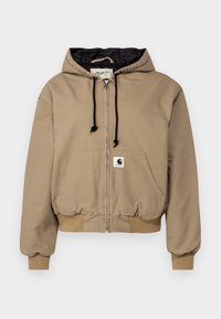 Beige rits-hoodie met een zwarte gevoerde capuchon, trekkoorden, ribgebreide manchetten en een logo-label op de voorzak. Zachte stofstructuur.