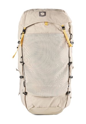 Sac à dos de randonnée beige avec une grande poche avant en mesh, des accents jaunes sur les sangles et des boucles latérales réglables.