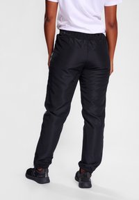 Zwarte, lichte sportbroek met een elastische tailleband en manchetten, met een zachte textuur en een relaxte pasvorm. Geschikt voor actieve kleding.