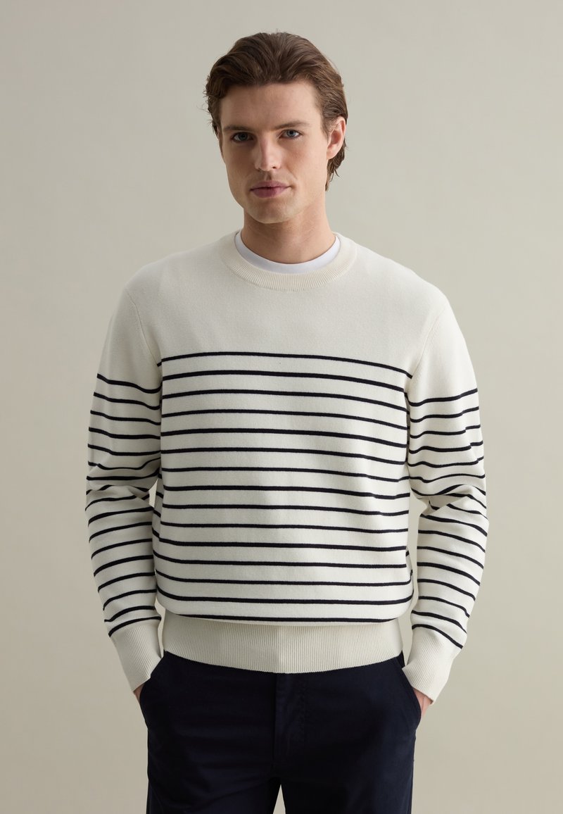 Pullover sweater in cream with navy horizontal stripes. Crew neck, ribbed cuffs and hem. Soft knit texture. Classic fit design.