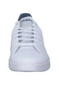 Vit sneakers med överdel i slät läder, rund tå och platta skosnören. Har tre sidostripes och en vadderad krage.