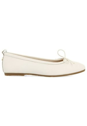 Ballerine blanche en matériau synthétique lisse, dotée d'un bout arrondi, d'un nœud décoratif sur le dessus et d'une semelle basse et flexible.