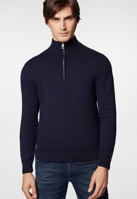 Granatowy sweter z dzianiny z wysokim kołnierzem i ćwierć zamkiem, z prążkowanymi mankietami i dołem. Miękka tekstura, luźny krój i długie rękawy.