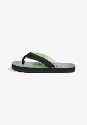 Grüne und schwarze Flip-Flops mit strukturiertem Sohlen, ausgestattet mit einem schwarzen Riemen. Die Sohle ist mit geometrischen Formen gemustert und aus Gummi gefertigt.