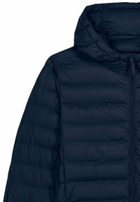 Veste matelassée bleu marine avec coutures horizontales, fermeture éclair avant et capuche attachée, vue des épaules au milieu du torse sur fond blanc.